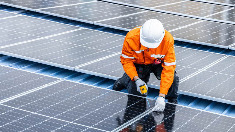 Maintenance worker fixing solar panel