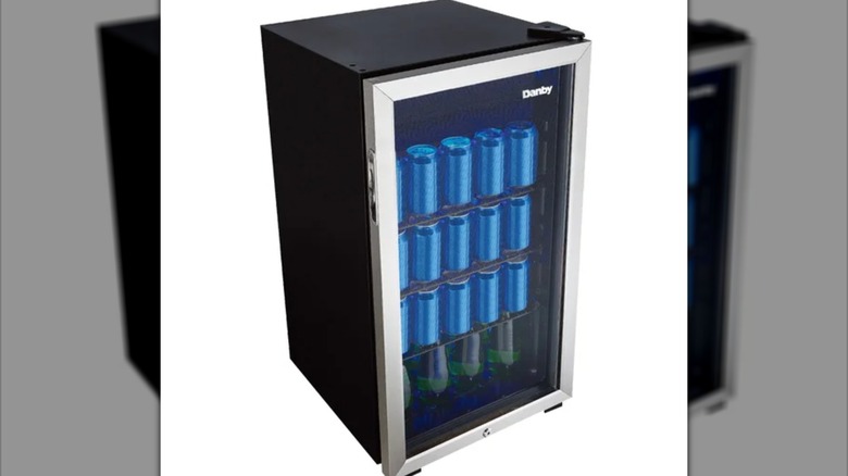 A Danby mini fridge stocked with canned drinks.