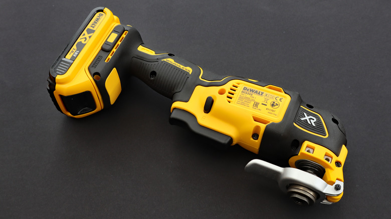 A DeWalt oscillating multi-tool on a black surface