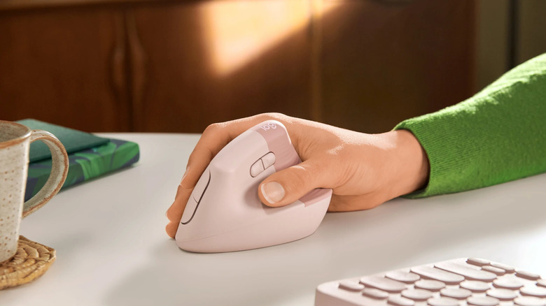 Hand holding pink Logitech Lift mouse