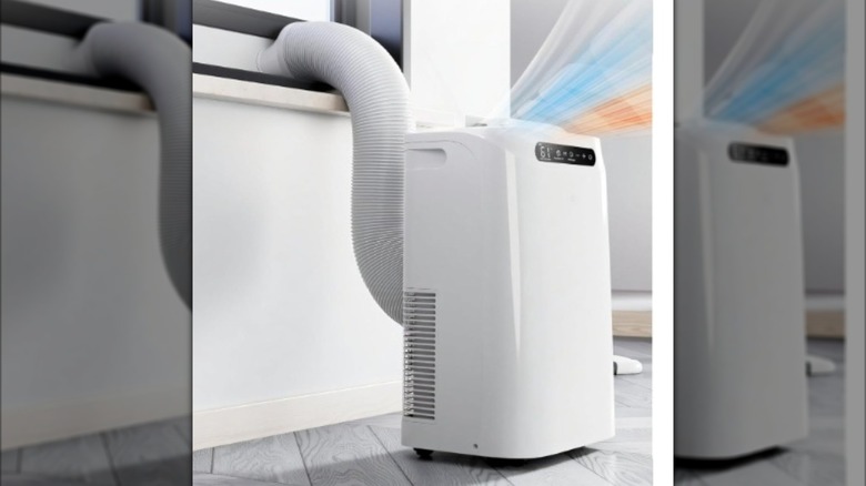A Portable white Air Conditioner and Heater with its hose leaving through a window frame