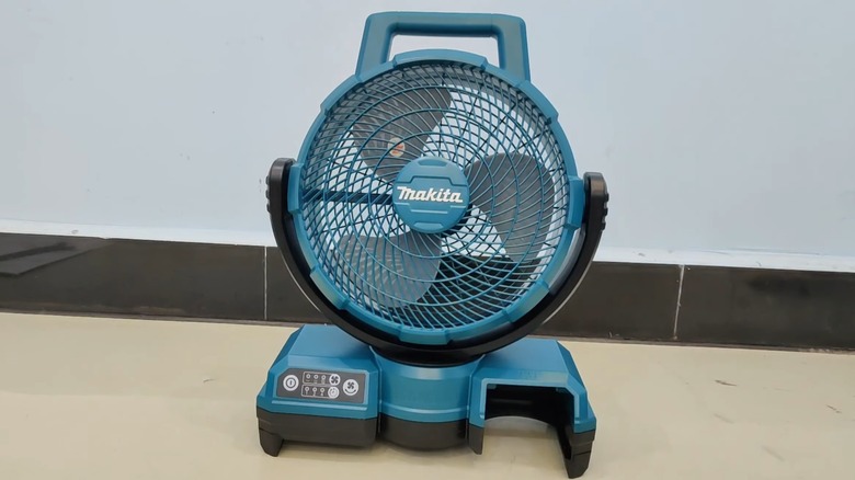 A Makita cordless fan on a floor.