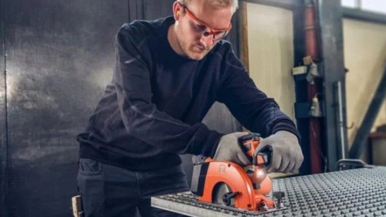 Worker using Fein 18V Compact Cordless Metal Circular Saw