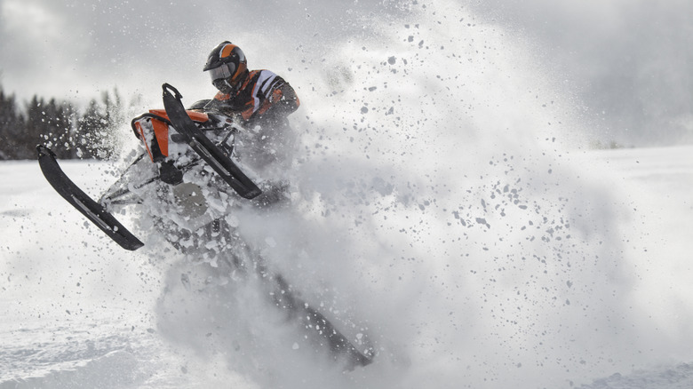 Person Riding A Snowmobile Over Deep Powdered Snow