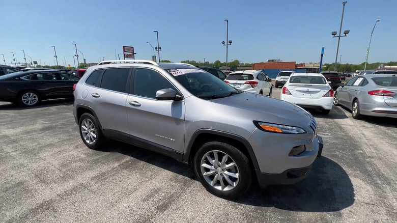 A silver 2018 Jeep Cherokee parked in a dealership