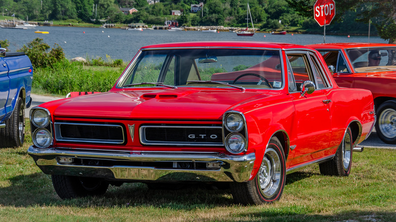 Red Pontiac GTO parked on grass