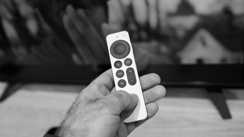 Person holding an Apple TV remote
