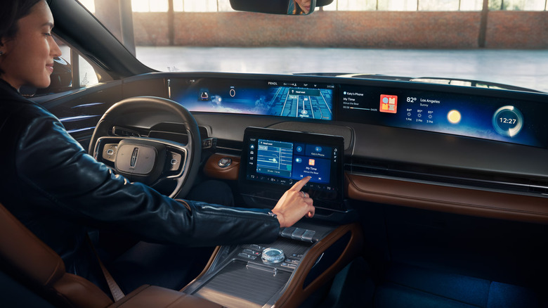 A person interacting with a large new 2026 Lincoln Nautilus dashboard display.