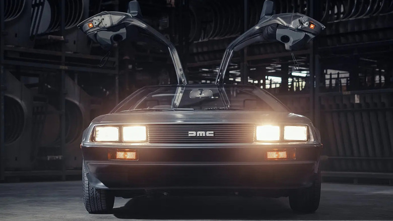 Front view of a DeLorean DMC-12 with headlights on and doors open