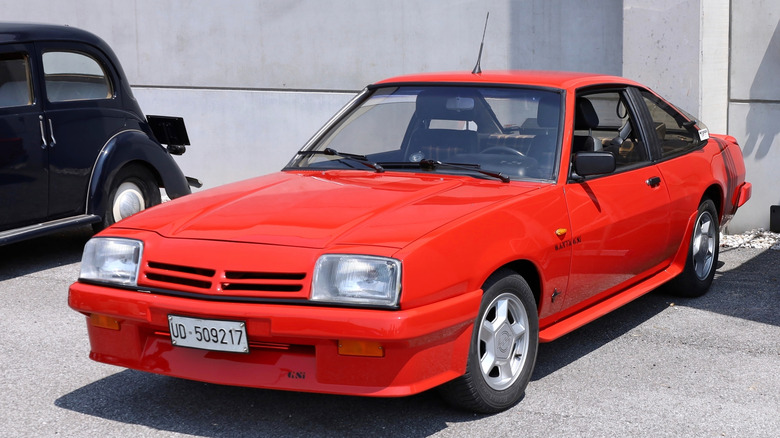 Red Opel Manta B parked in front of a building