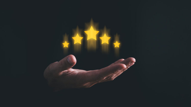Holographic image of five yellow stars above a man's hand