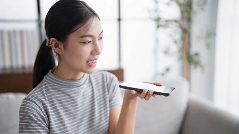 Woman holding a smartphone speaking into it