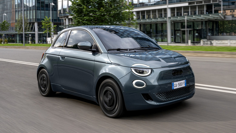 Front 3/4 view of Fiat 500e on the move, dark bluish gray exterior