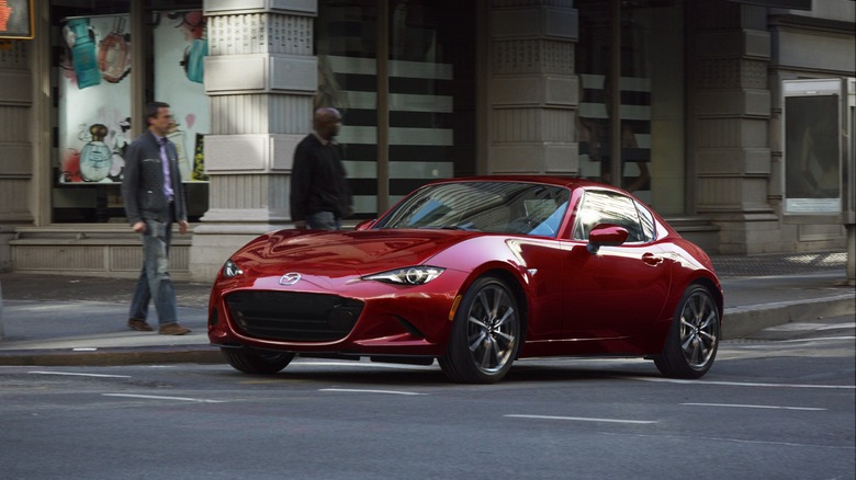 Front 3/4 view of Mazda MX-5 Miata in Soul Red Mica on a city street