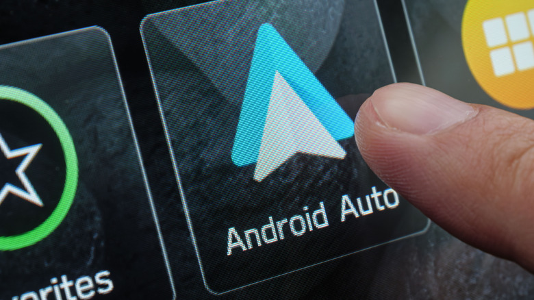Finger activating andoird auto app on vehicle touchscreen.