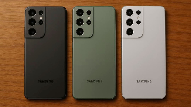 Three Samsung S21 smartphones in different colored cases lined up face-down on a wooden background