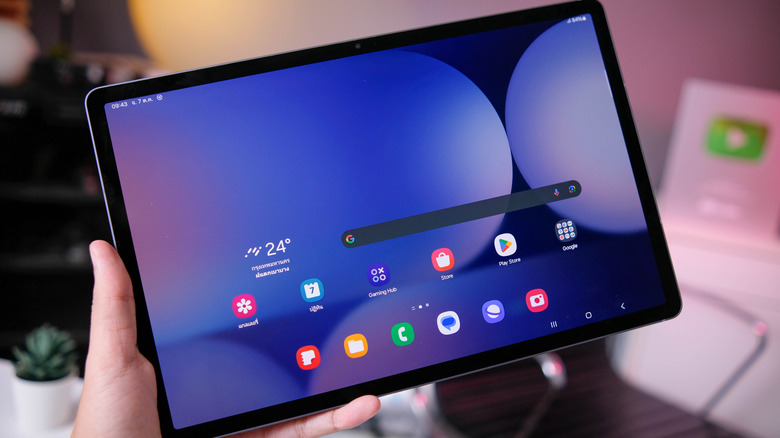 Someone holding Samsung Mobile Galaxy Tab S10 with a blue screensaver