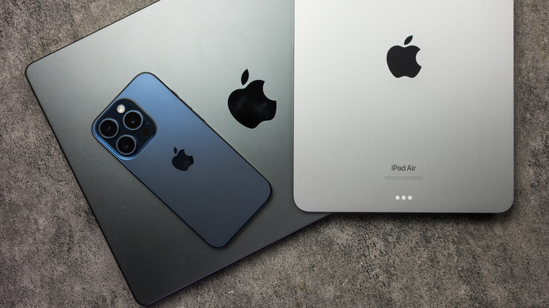 An iPad and an iPhone placed on top of a MacBook