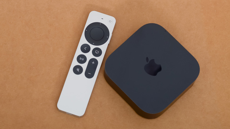 An Apple TV 4K device with its remote