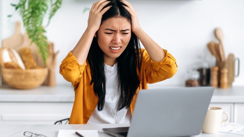 Frustrated person using a laptop