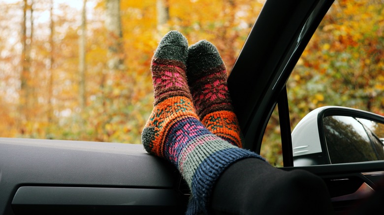 Passenger kicking socked feet up on the dashboard