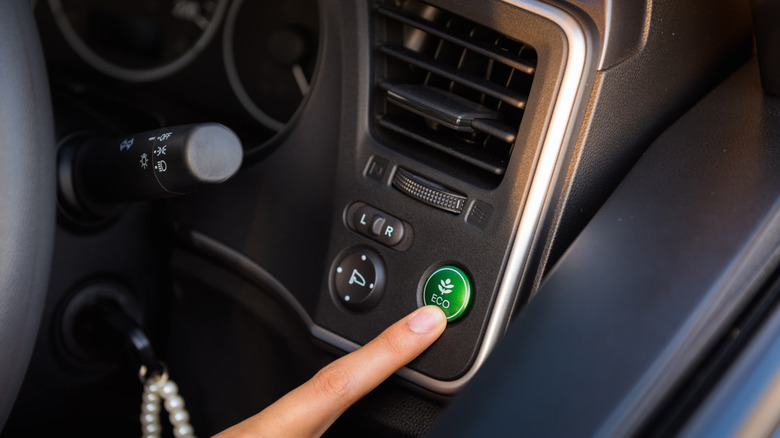 A finger pressing the eco mode button