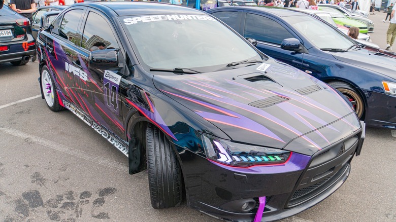 A Mitsubishi Lancer with a custom paint job at a car event