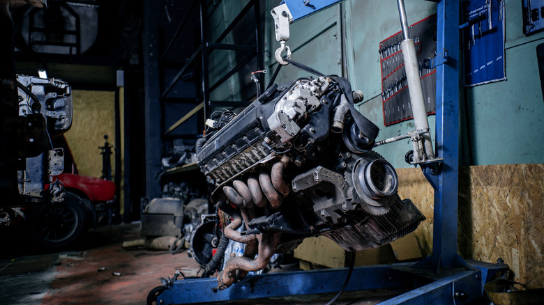 An old car engine on a hoist