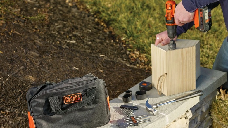 Person using a Black+Decker drill