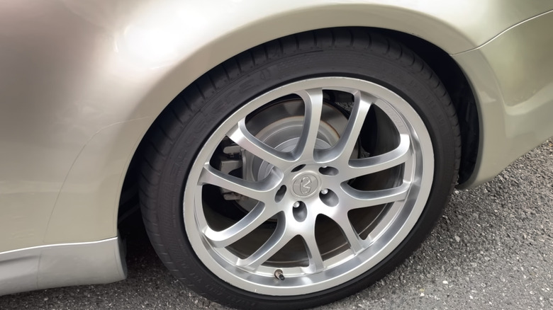 An Accelera PHI tire mounted on a champagne-colored car.