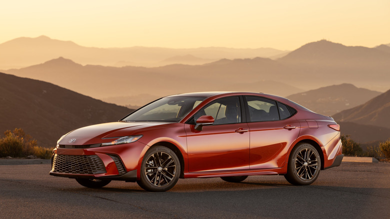 2026 Toyota Camry parked with mountain landscape background, left-side view