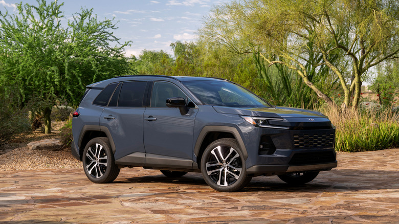 2026 Toyota RAV4 parked among green shrubbery, front-right 3/4 view