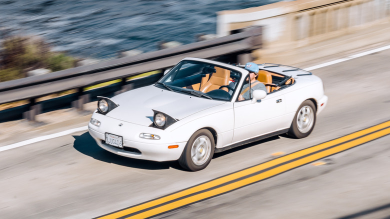 A first-gen Miata with the roof down
