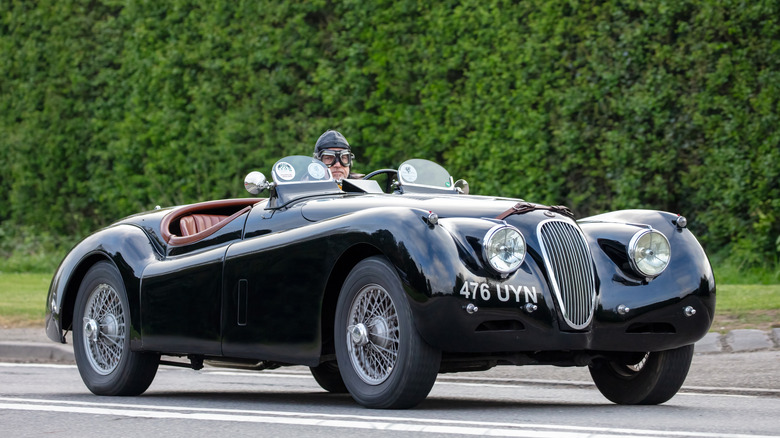 1954 Jaguar XK120 Roadster with driver in period-correct racing gear
