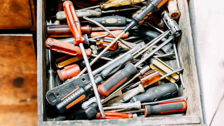 A closeup of a drawer cluttered with a variety of tools