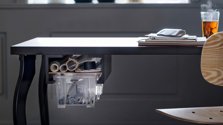A DIY desk drawer made with two black MOSSLANDA picture ledges and a SAMLA storage box