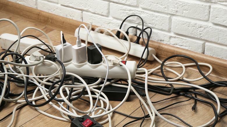 A jumble of cables on a wooden floor.