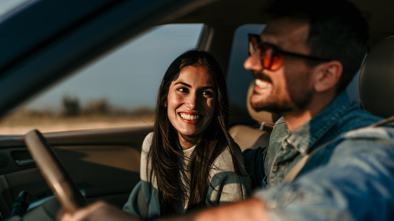 a couple smiling while sitting in a car