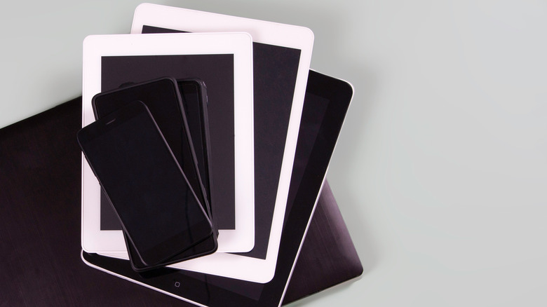 Pile of old used MacBook, iPad and iPhones