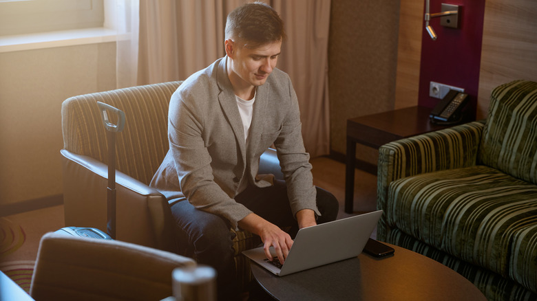 Person working on computer in a hotel suite