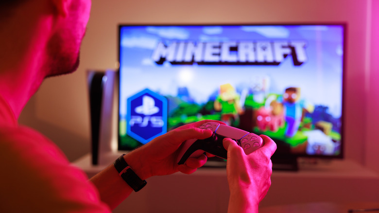 man playing Minecraft on television with controller