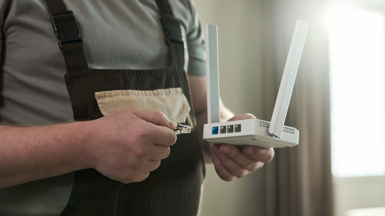 A repairman holding a Wi-Fi router