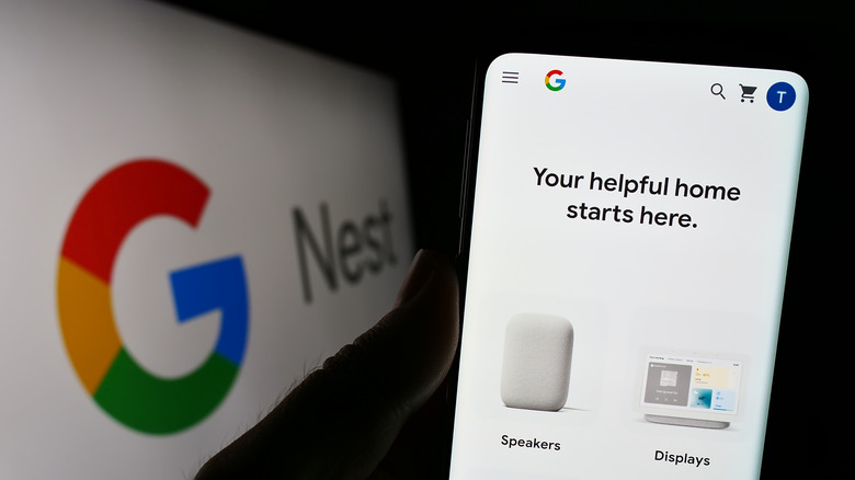 A person holding an Android smartphone in preparation to pair with a Google Home device, Google Nest splashscreen in the background