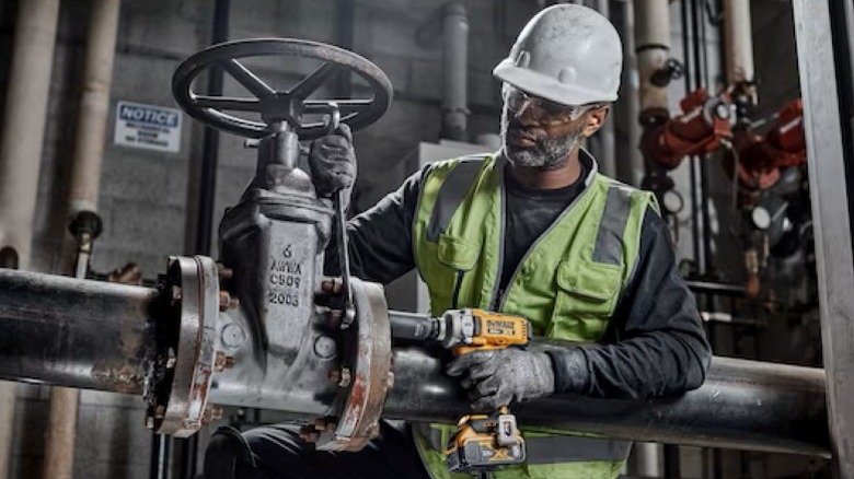 Person using impact wrench on fastener