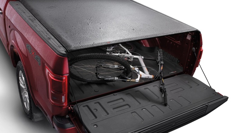 tonneau cover on red pickup with bicycle in back
