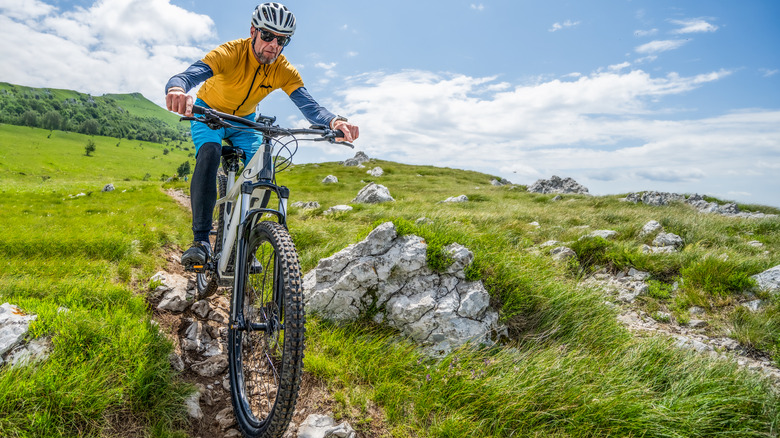 A man riding down a rocky trail on an electric bike.