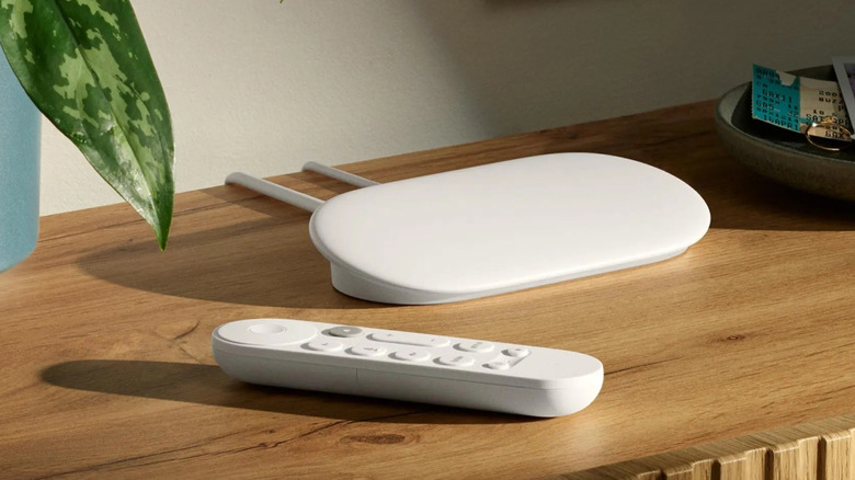 A Google TV Streamer with its remote in front of it on top of a table