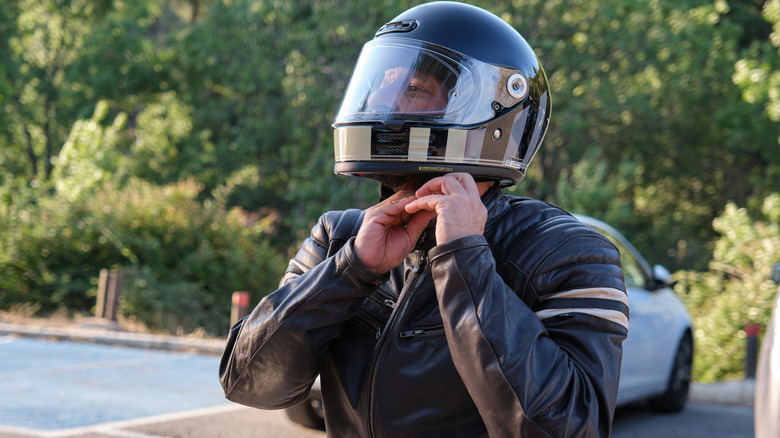 A biker puts on a helmet