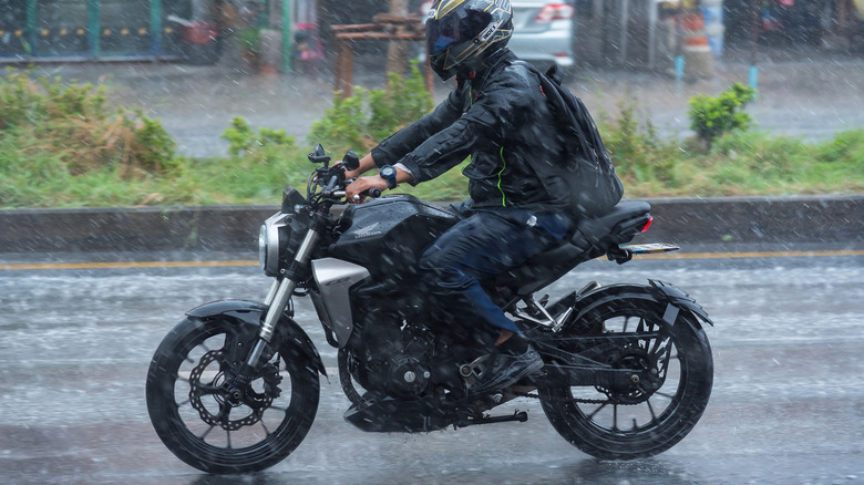 A person riding a motorcycle in the rain
