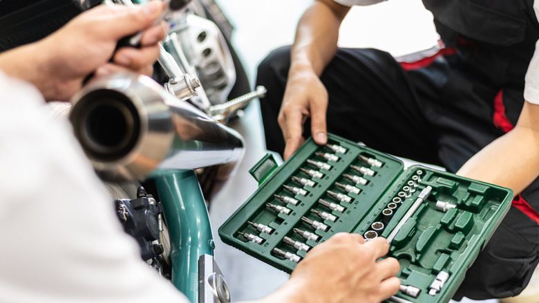 Two mechanics with a tool box in their hands